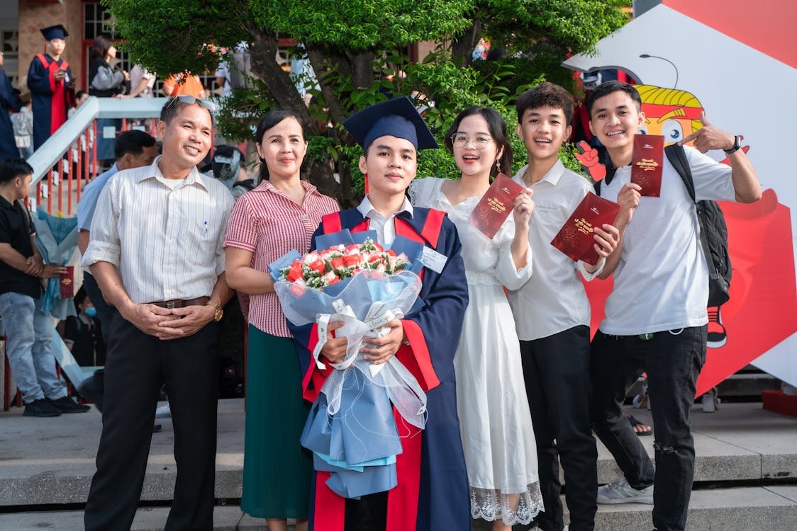 free-photo-of-happy-family-posing-with-son-after-graduation